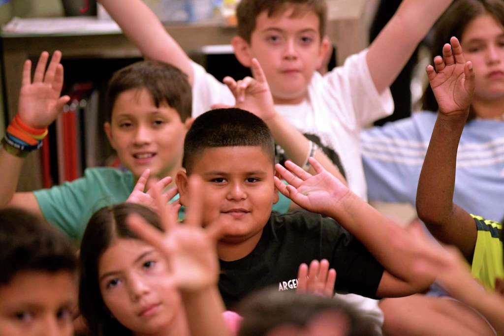 Students raise their hands in 2019. Teaching is a career that can make the world kinder and better and help others. A new teaching high school will foster this. courtesy of the San Antonio Express-News Billy Calzada /Staff Photographer